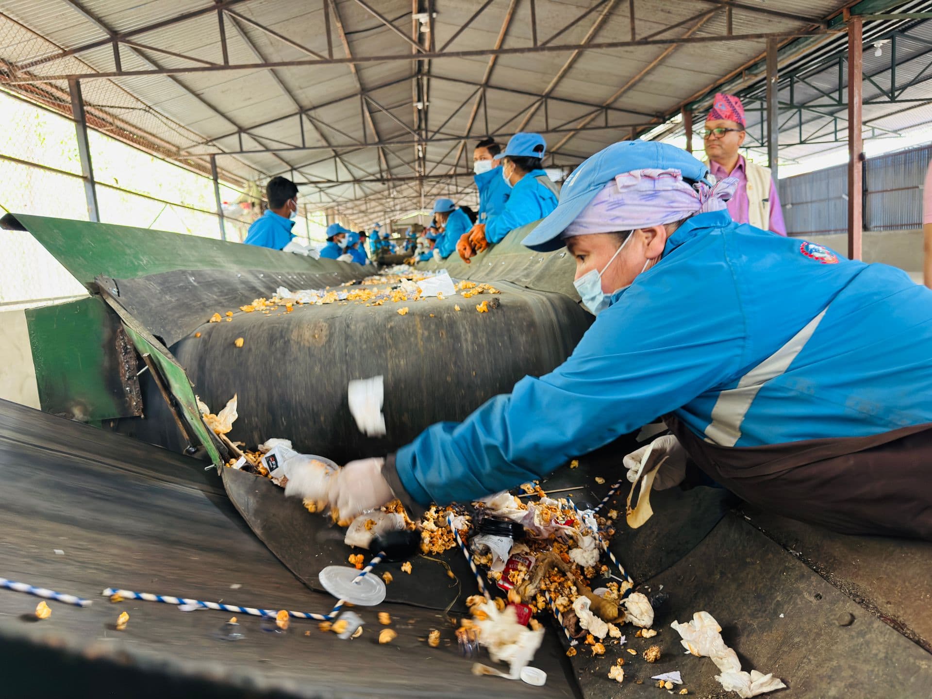Workers sorting recyclable material on a conveyor